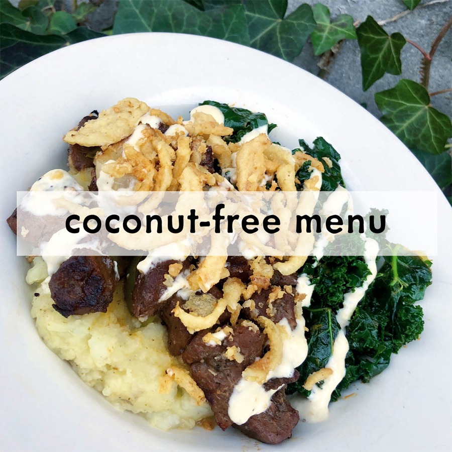 Plate of mashed potatoes topped with pieces of grilled meat, fried onions, and drizzled with creamy sauce. Kale on the side. Text reads "coconut-free menu."