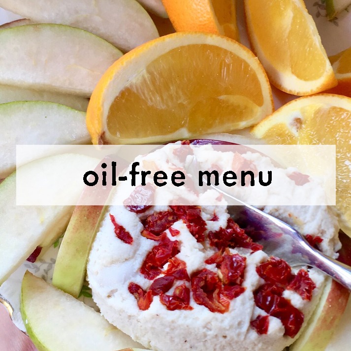 A plate of fresh apple and orange slices surrounds a round serving of cream cheese topped with dried cranberries. Text reads "oil-free menu."